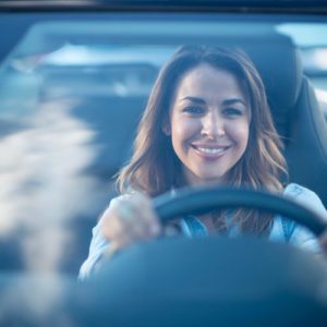Smiling woman in driver seat of vehicle