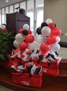 Red, black and silver balloons attached to door prize bags