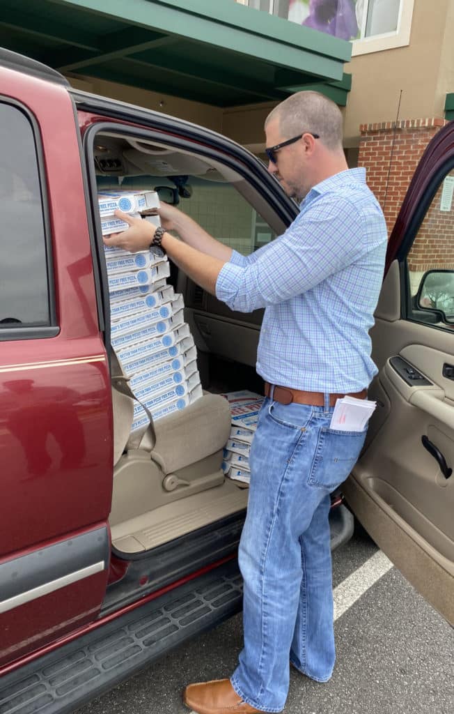 Lending Center Manager, Shay Roland grabbing pizzas