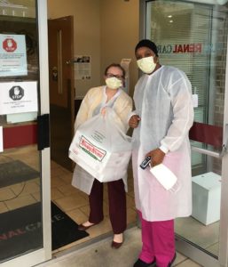 Employee of US Renal Care holding bag of fresh donuts