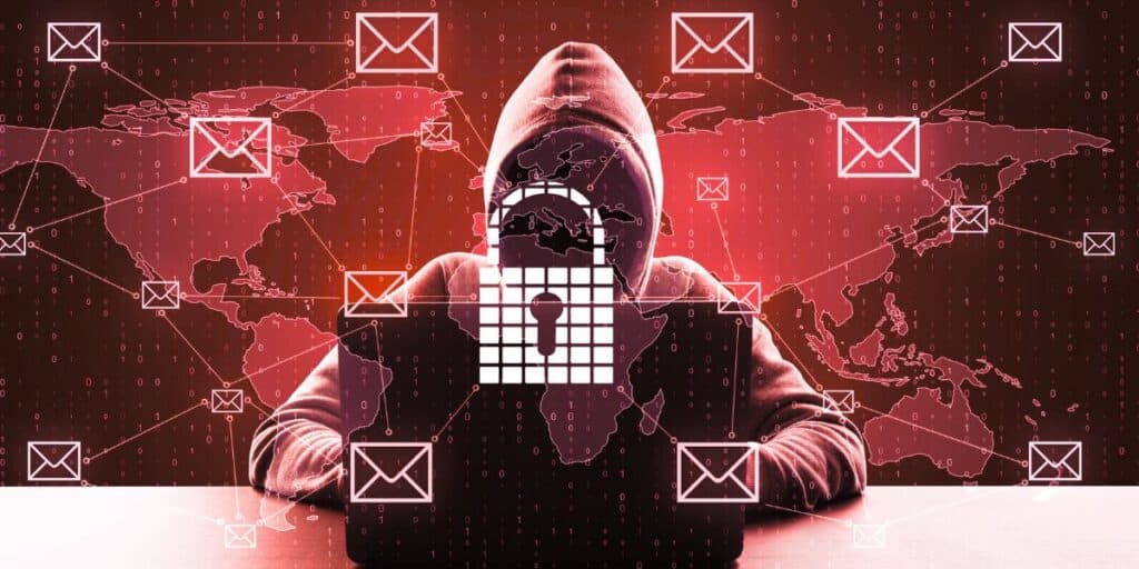 A hooded figure at a computer sits in shadow as padlock and email icons overlay a world map with binary code, hinting at hacking.